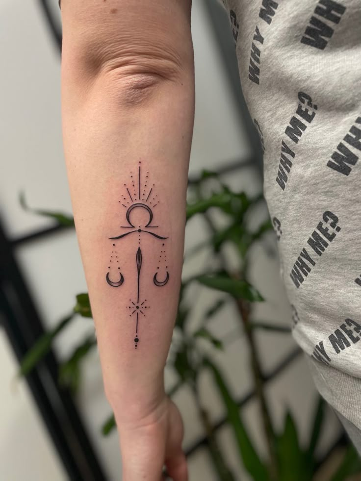 a woman's arm with a tattoo on it and an arrow in the middle