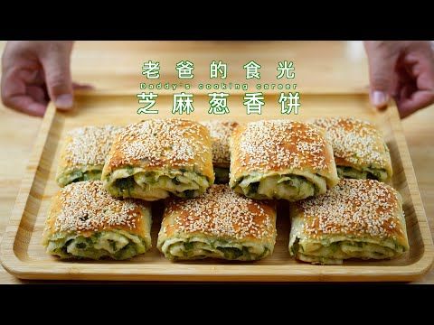 a wooden tray topped with cut in half sandwiches covered in cheese and spinach sauce