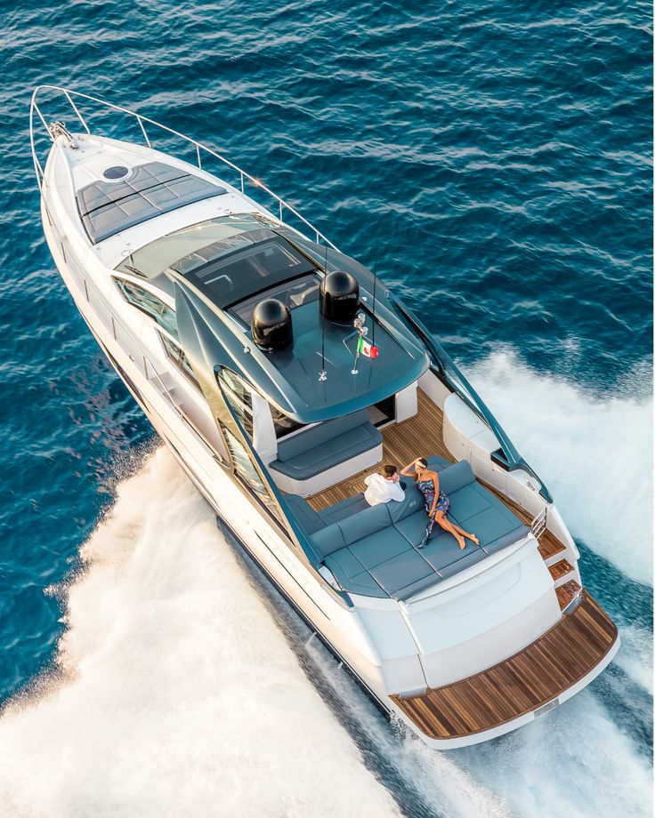 a woman is sitting on the back of a boat in the blue water with her feet up