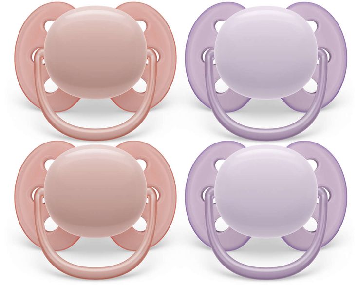 three pacifiers in different colors and shapes, one with an infant's head