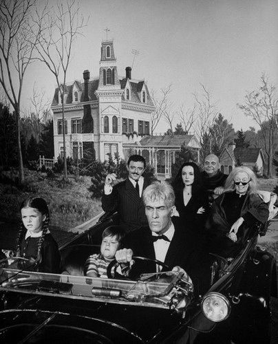 an old black and white photo of people in front of a house with a car