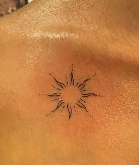 a sun tattoo on the back of a man's chest