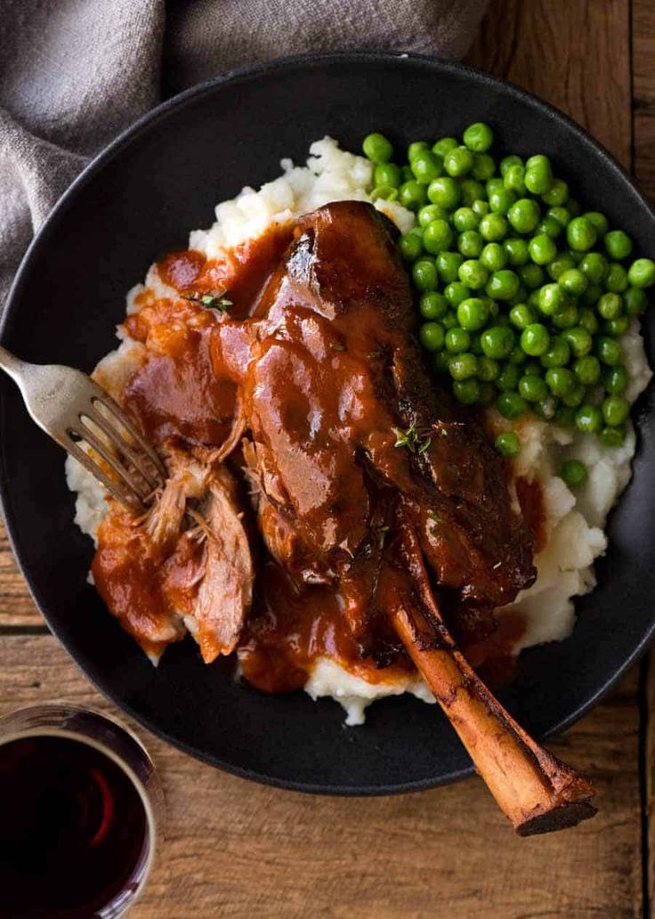 a plate with meat, mashed potatoes and peas