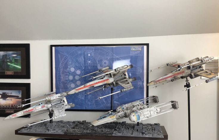 a star wars model is on display in a room with pictures and other items around it