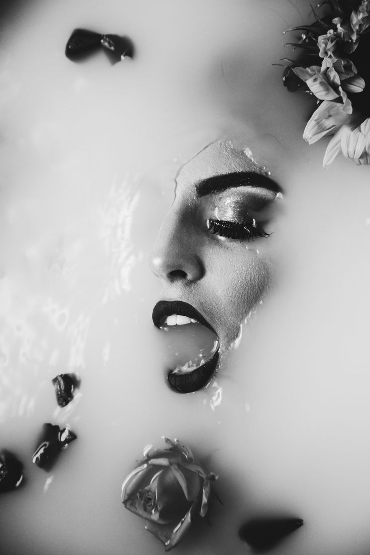 a woman with flowers on her head is submerged in water