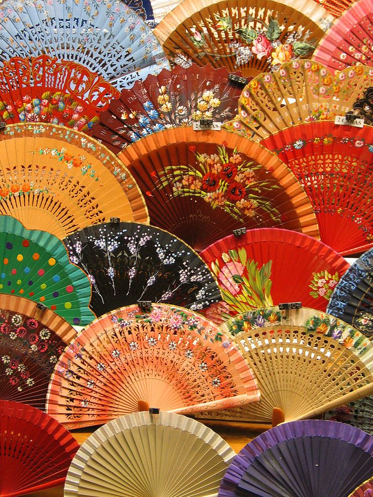 many colorful fans are stacked together in the shape of fan's, with different colors and designs on them