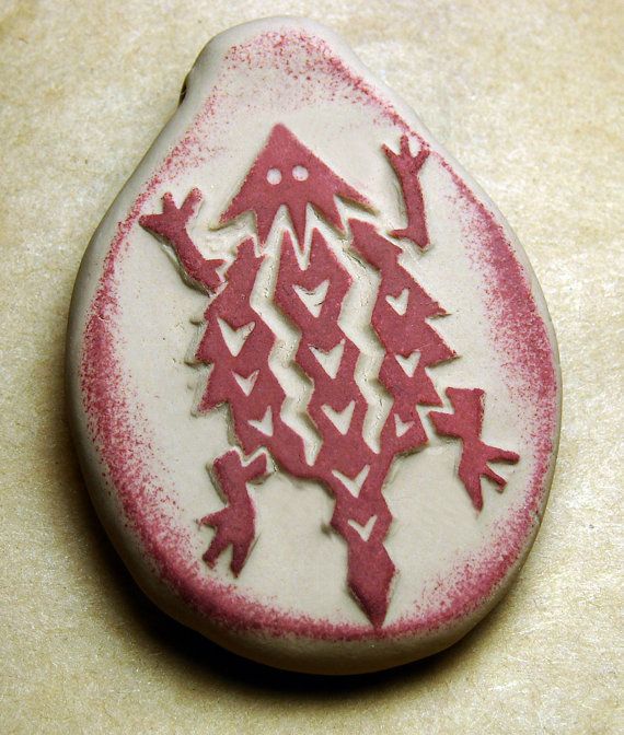 a red and white brooch sitting on top of a table