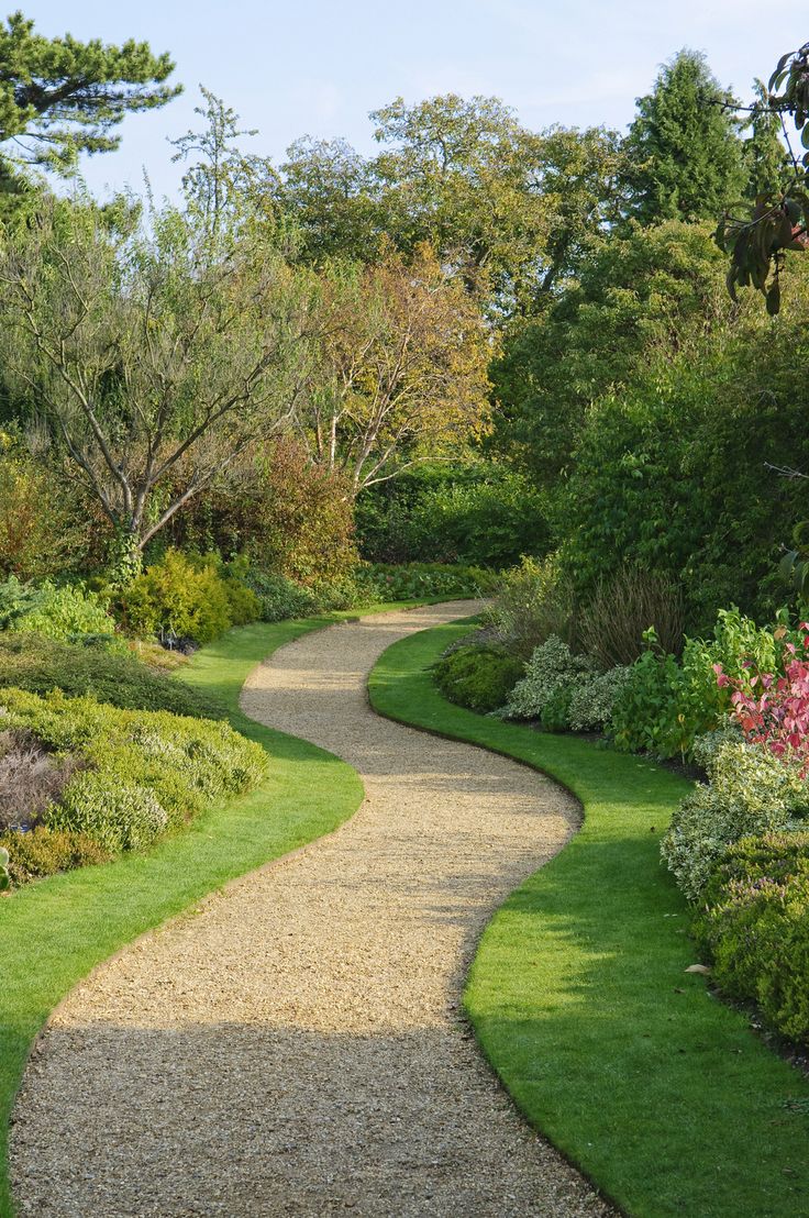 a pathway in the middle of a lush green park