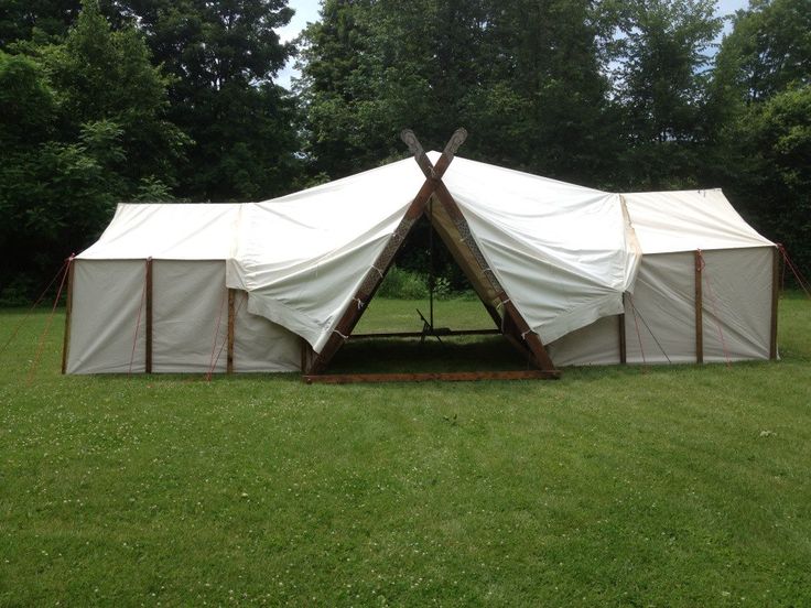 a tent set up in the middle of a field with two poles sticking out of it