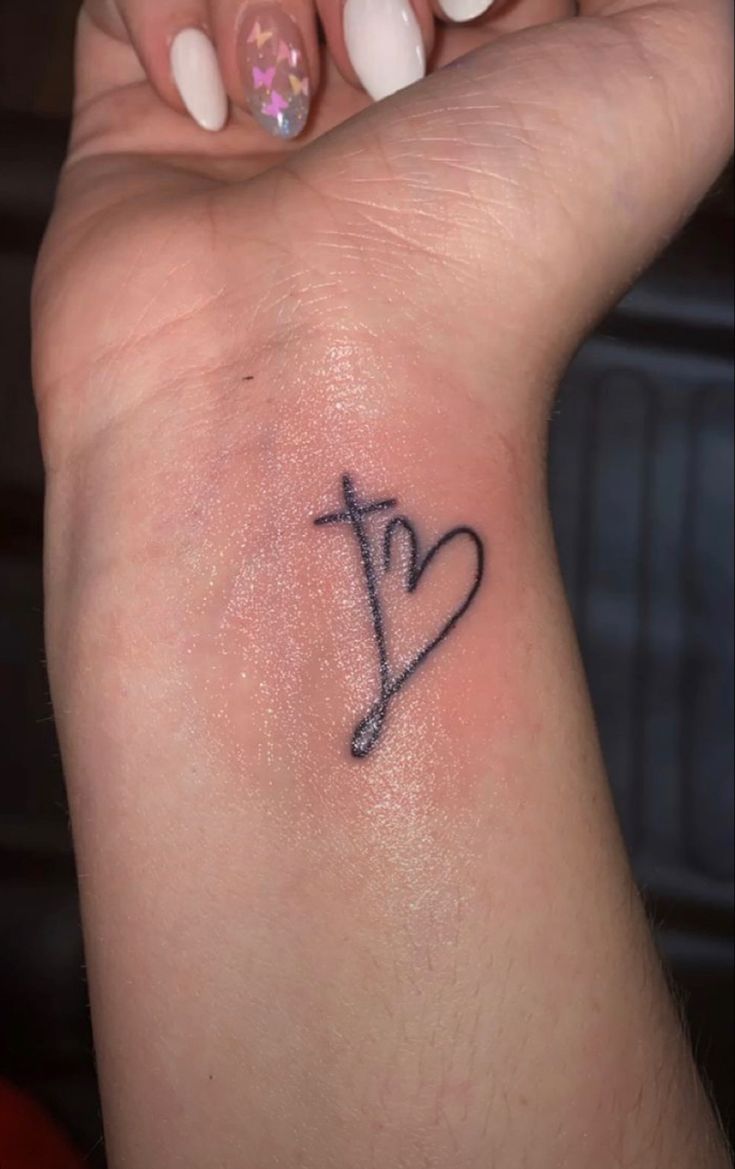 a woman's arm with a small tattoo on the left side of her wrist