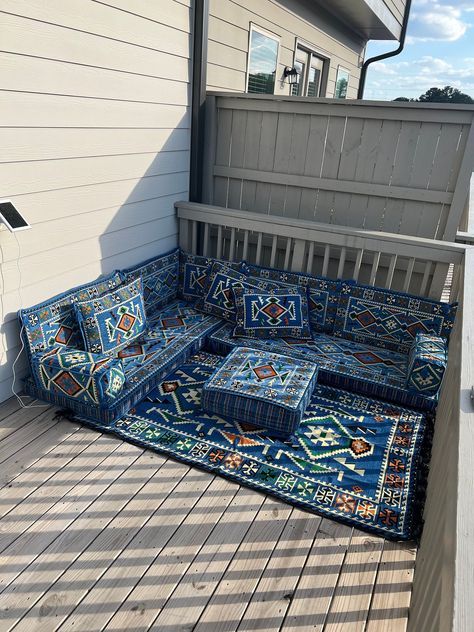 a blue couch sitting on top of a wooden deck