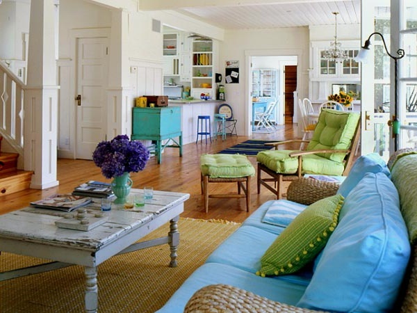 a living room filled with lots of furniture next to a wooden floor covered in white walls