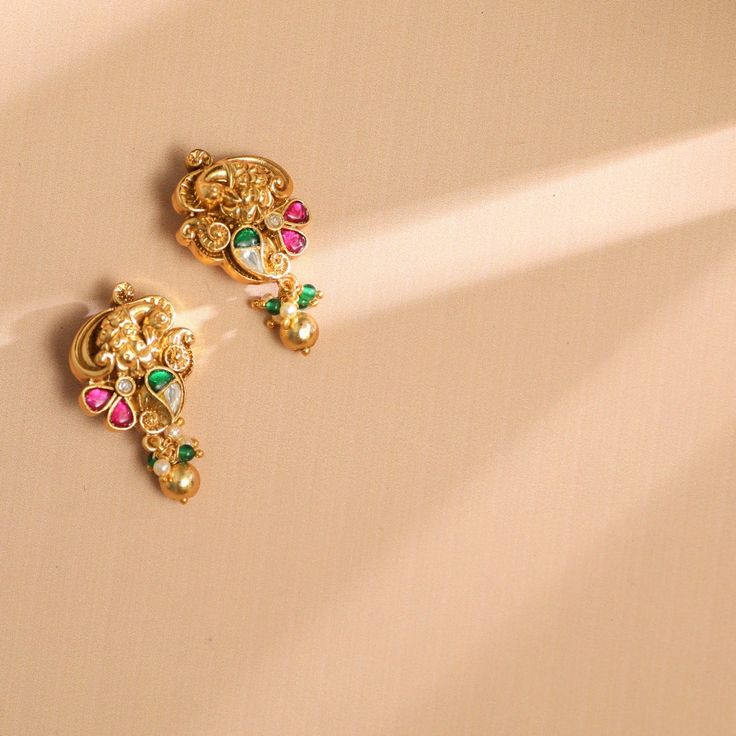 Description This timeless drop earring is perfectly crafted with kempu and polki stones on a gold-plated setting and finished with gold drop balls. An elegant wardrobe essential, these daily earrings will be your favorite. Style with the complementary accessories from the Vihara family for a grand look. Product Information Materials used: 925 Silver with 1.0-microns Antique Gold Plating Stones: Semi precious stones Length: 3.5 cm Findings: Hook & links Daily Earrings, Elegant Wardrobe, Antique Gold Earrings, Gold Temple Jewellery, Gold Jewellry, Ayurvedic Remedies, Peacock Earrings, Antique Bridal Jewelry, Bangles Design