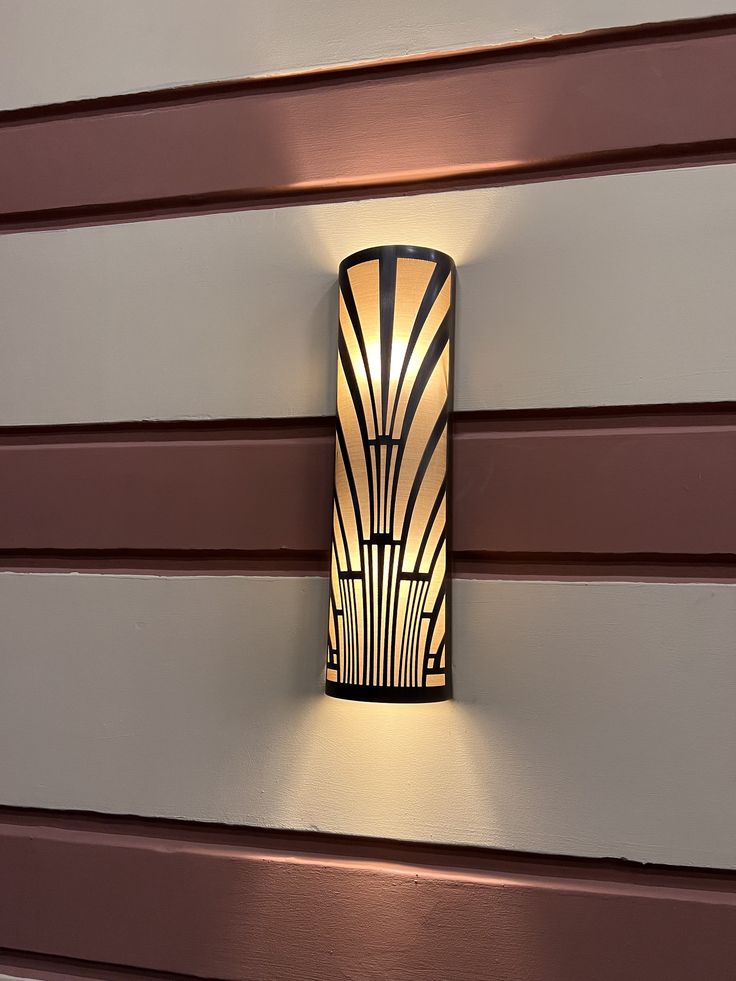 a wall light mounted on the side of a building with red and white sidings