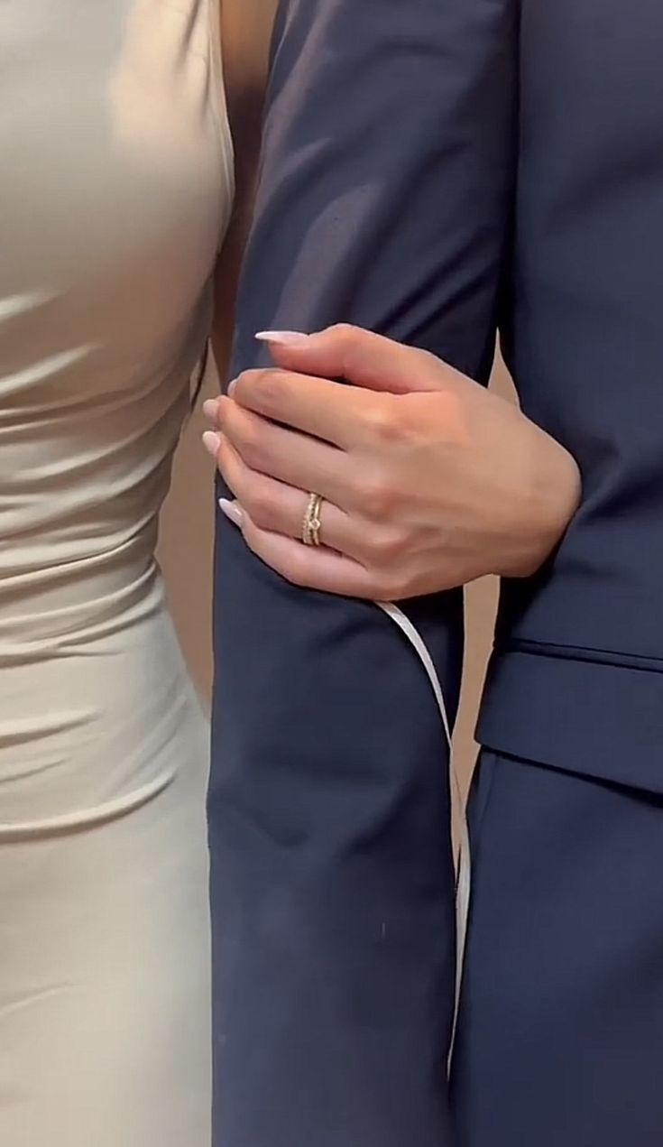 two people in formal wear hold their hands together