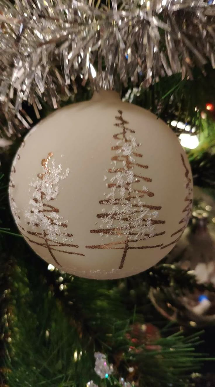 a white ornament hanging from a christmas tree