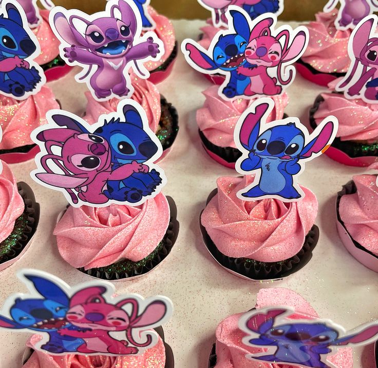 cupcakes with pink frosting and cartoon characters on them are arranged in rows