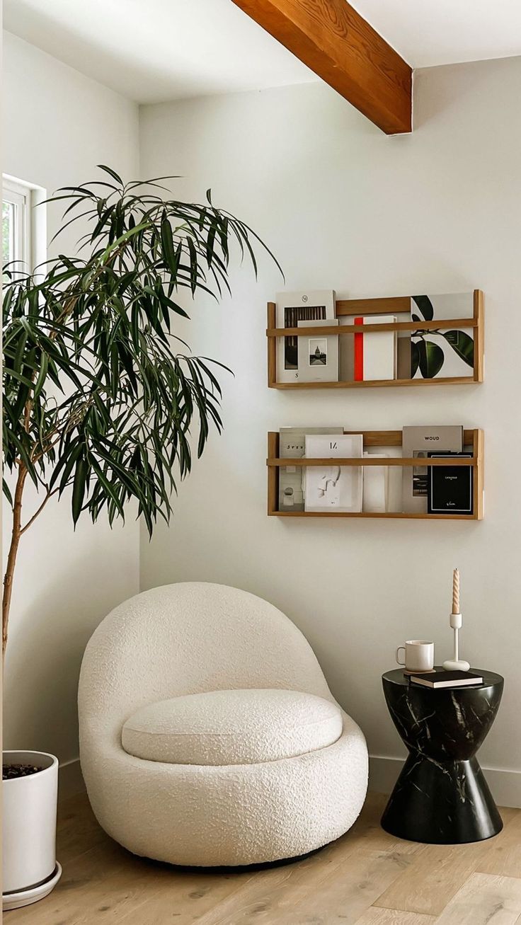 a living room with a potted plant next to a white chair