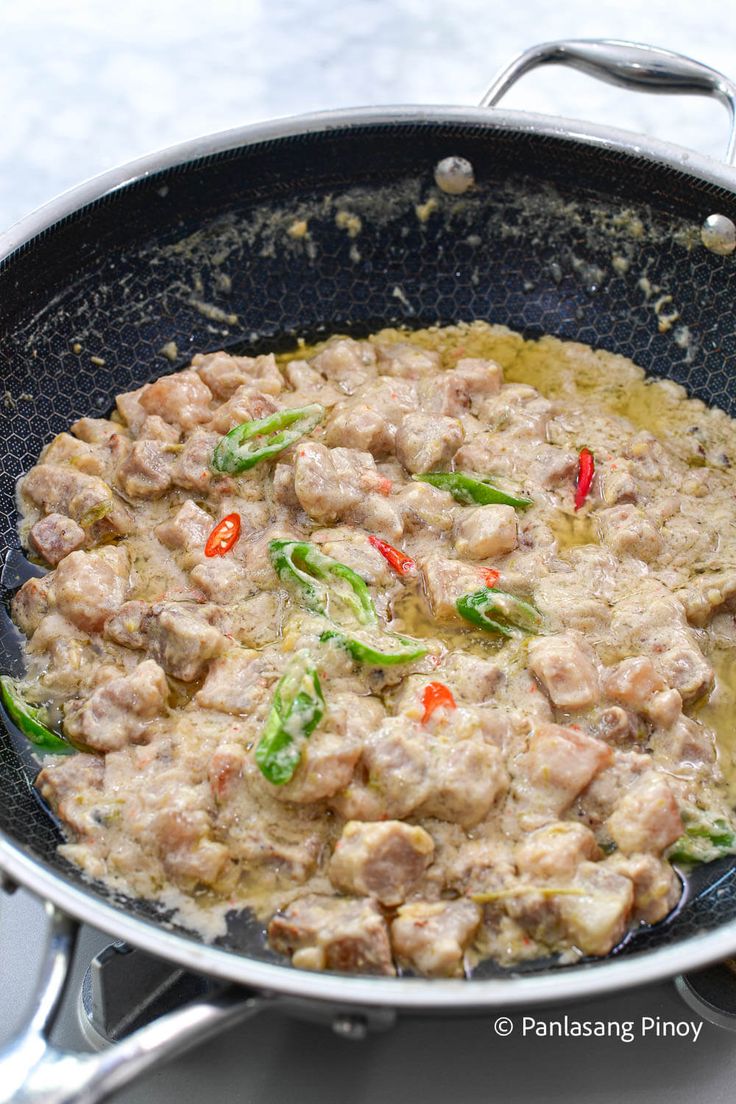 a pan filled with meat and vegetables on top of a stove