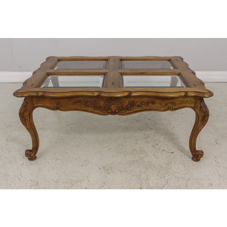 an antique coffee table with glass top