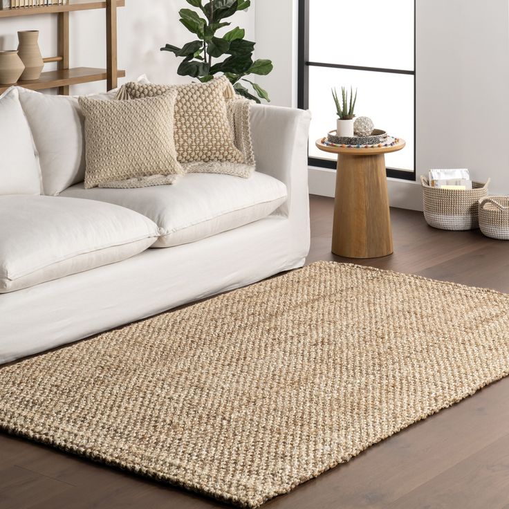 a living room with white couches and pillows