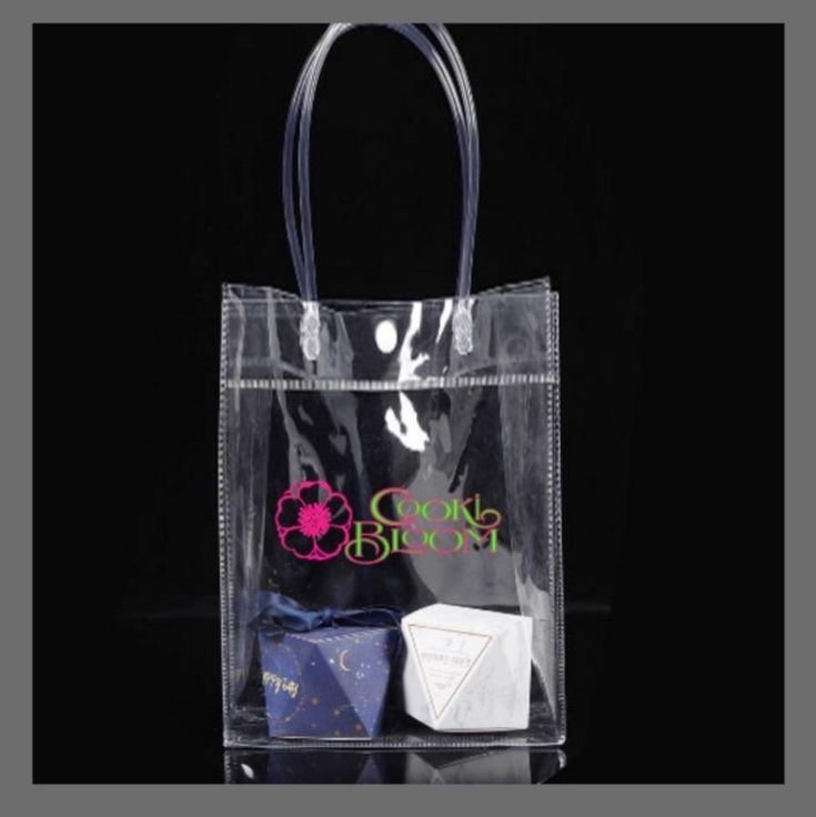 Carry it all in your Cooki Bloom Shopper Bag today! Ships FREE!!! This bag comes included with every order that includes a shirt. Grab one for a friend while you're shopping. Specifications Transparent bag with logo on one side. Durable PVC material with top handles for easy and stylish carry. Perfect for events that only allow clear bags. One white button snap closure. 33.3cm height x 24.3cm width x 6.3cm depth Clear Tote Bag For On-the-go, White Clear Plastic Bag For Daily Use, Trendy Pvc Bags For Everyday Use, Daily Use Clear Plastic Bags, Clear Plastic Bags For Everyday Use, Clear Pvc Bags For Daily Use, Everyday Use Clear Plastic Bag, Daily Use Clear Pvc Bags, Clear Tote Bag For Gift