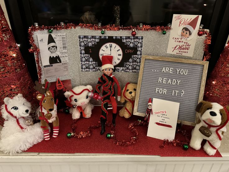 a group of stuffed animals sitting on top of a red carpet next to a sign