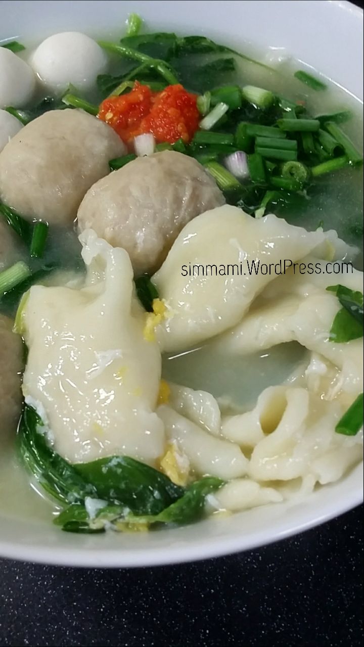 a close up of a bowl of food with broccoli and dumplings in it