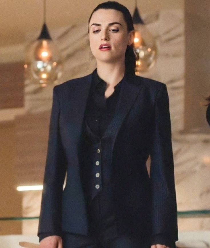 a woman in a black suit is standing