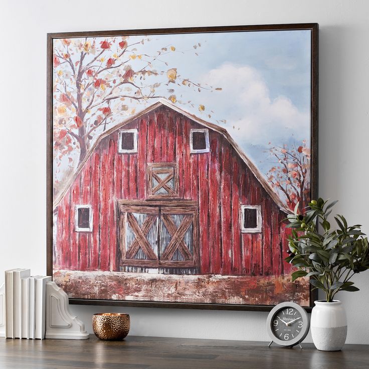 a red barn painting hanging on the wall next to a clock and bookshelf