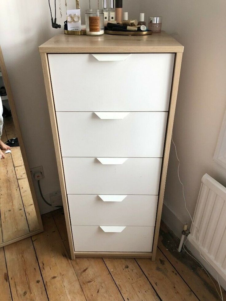 a white chest of drawers sitting on top of a wooden floor