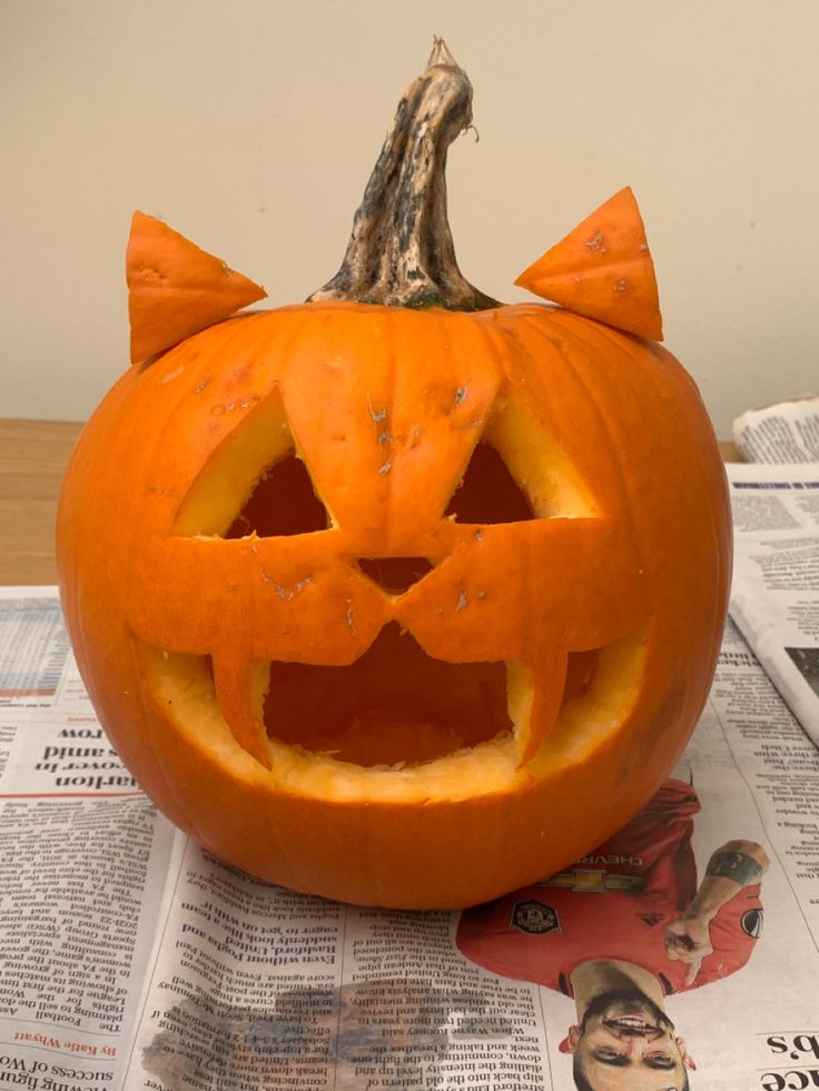 an orange pumpkin carved to look like a cat