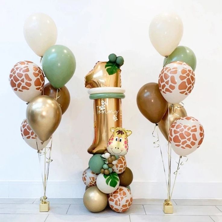 balloons and giraffes are on the floor in front of a wall