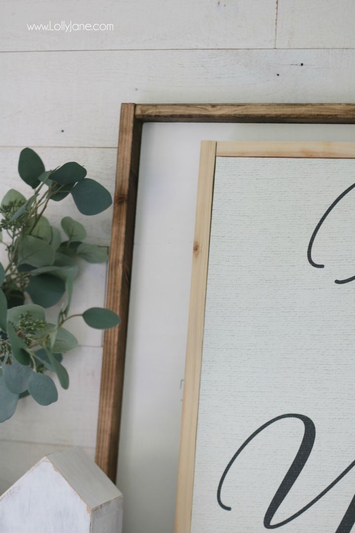 a framed canvas with the word love on it next to a potted green plant