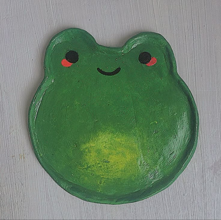 a green frog shaped plate with red eyes