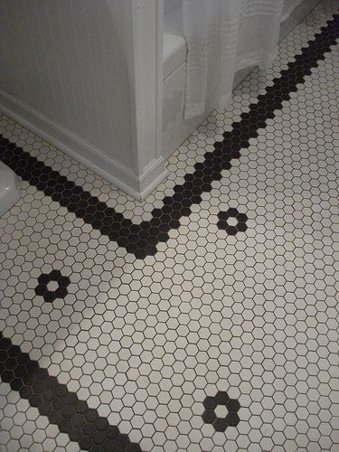 a bathroom with black and white hexagonal tiles on the floor