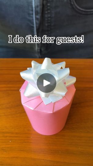 a pink box with white bows on it and the words i do this for guests