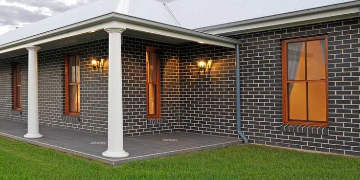 a brick house with white pillars and windows