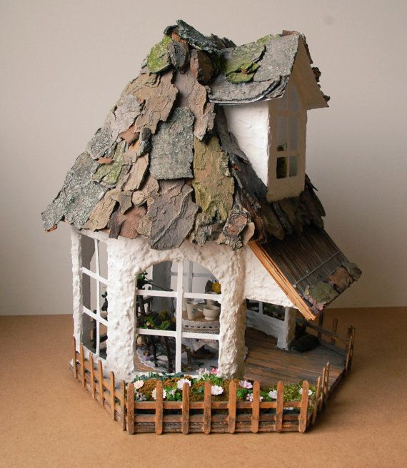 a doll house made out of paper and wood with a roof that is covered in moss