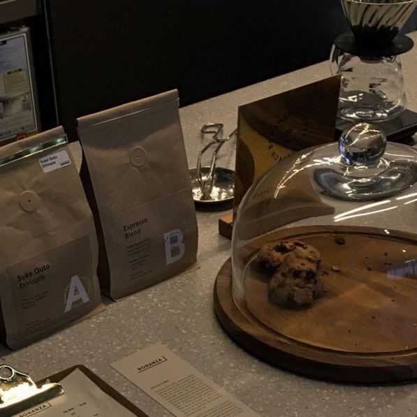 there is a glass dome on top of the counter with coffee beans and cookies in it