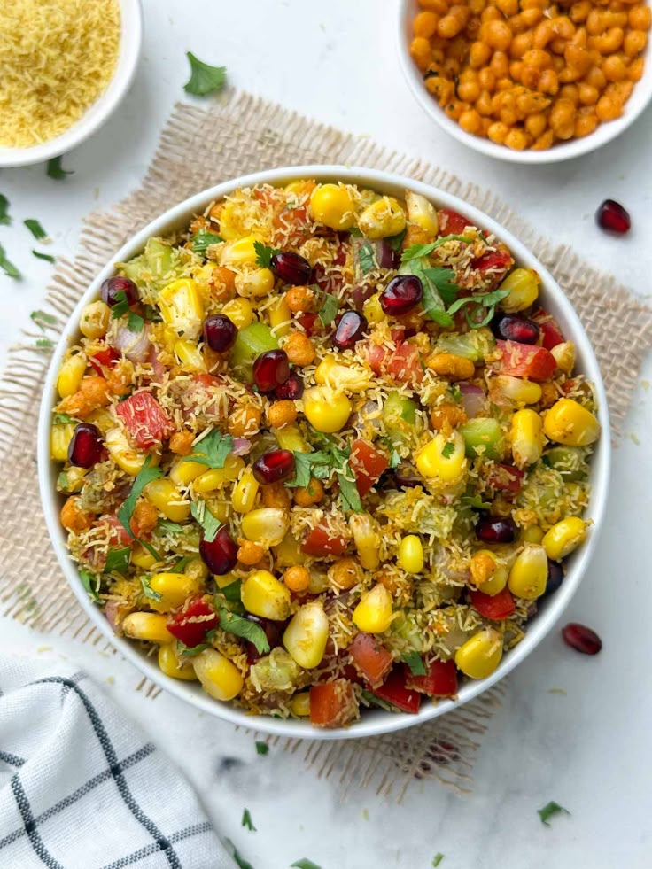 a bowl filled with rice and vegetables next to two bowls full of chickpeas