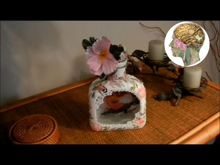 a vase with flowers sitting on top of a wooden table next to candles and other items