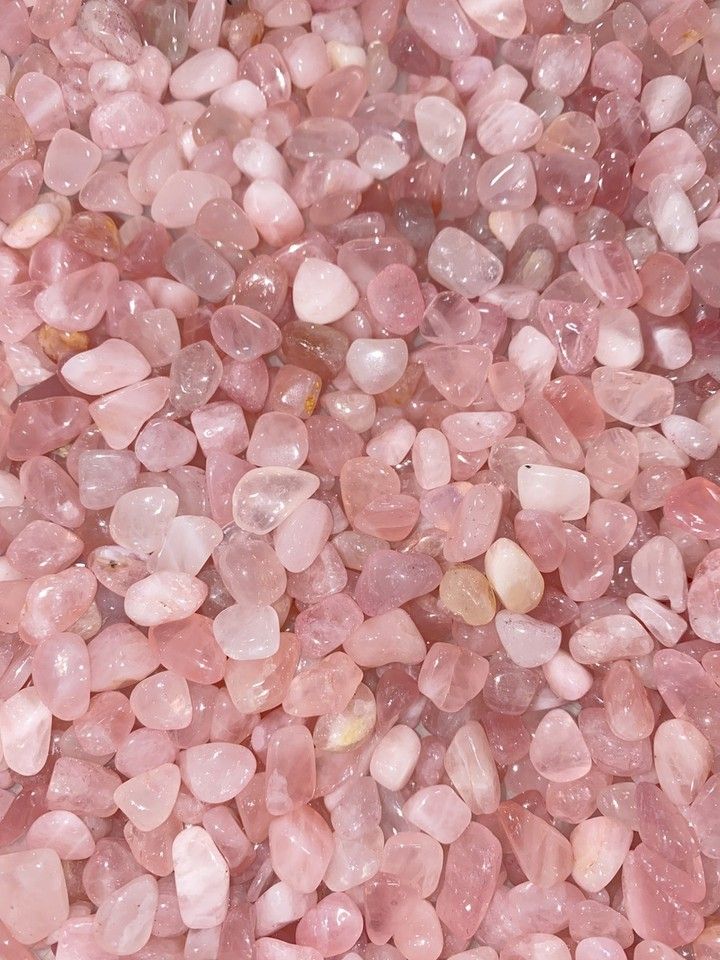 some pink rocks and gravel on a white surface