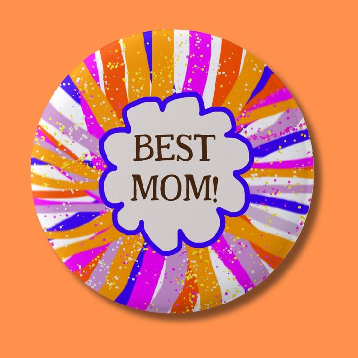 a badge with the words best mom on it in front of an orange and pink background