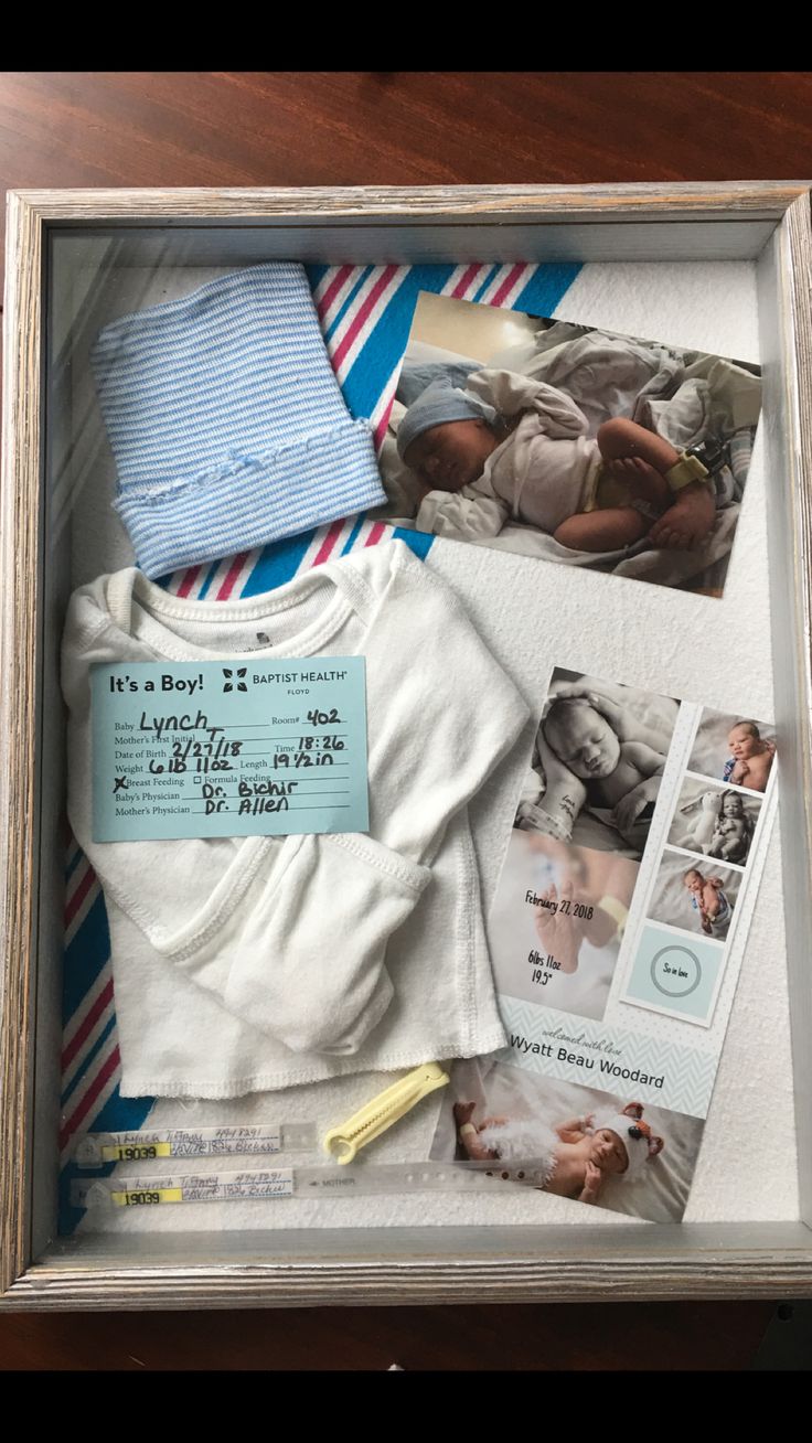 a baby's first year gift in a shadow box with clothes and other items