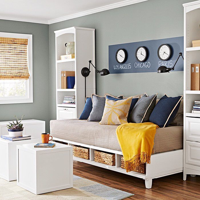 a living room filled with furniture and lots of storage under the clock on the wall