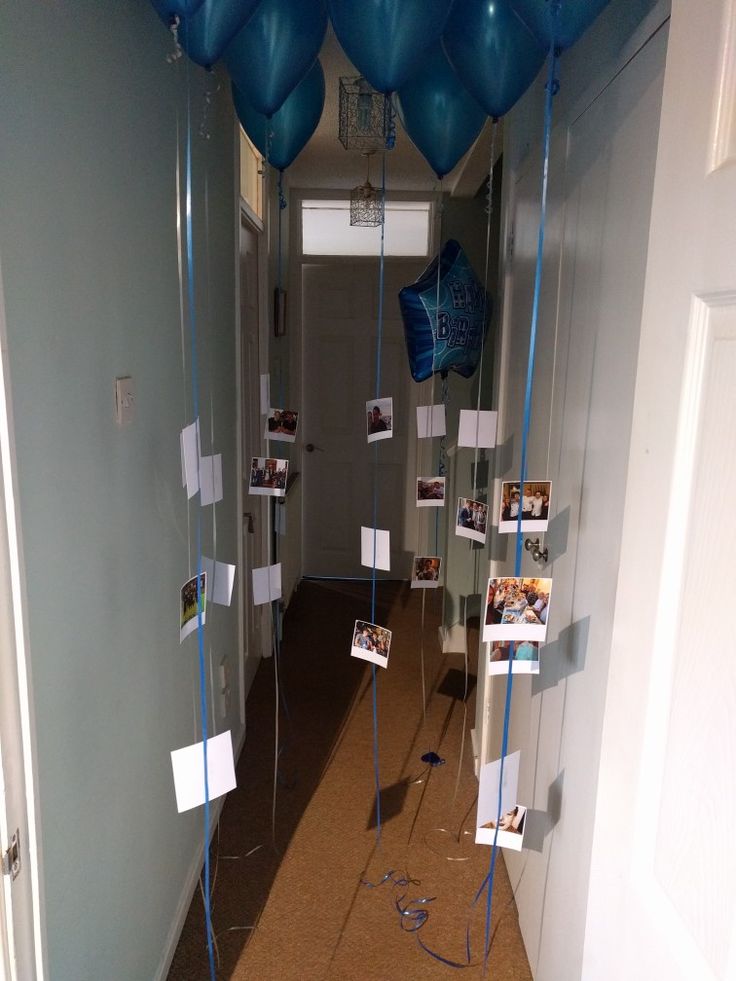 blue balloons are hanging from the ceiling in an office hallway with pictures and photos on them