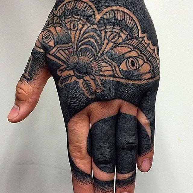 a person's hand with black and white tattoos on it