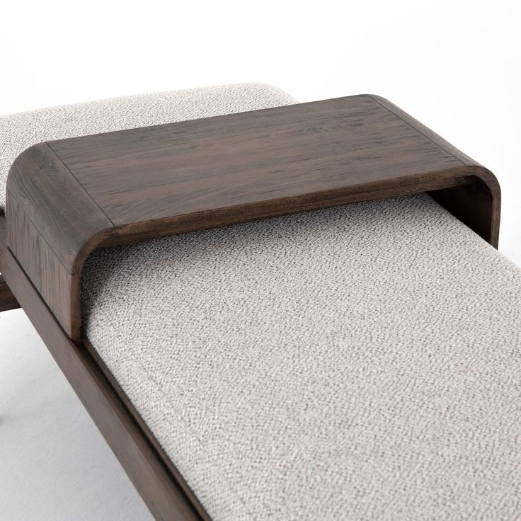 a wooden bench sitting on top of a white carpet