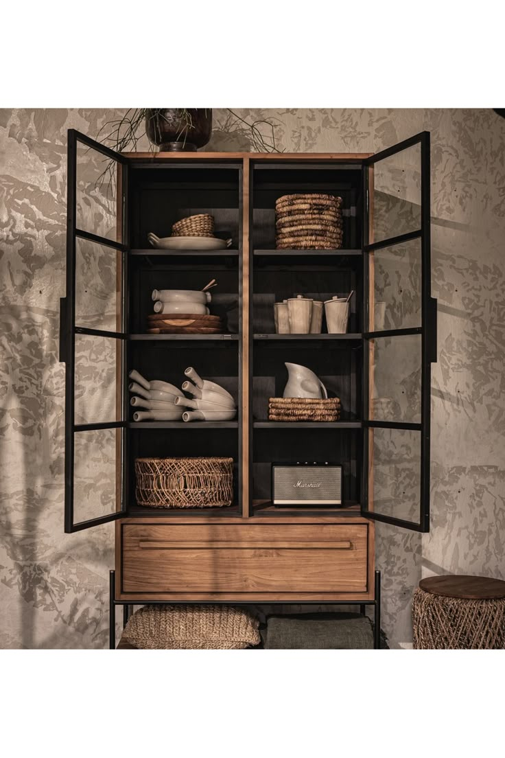 an open bookcase with baskets and dishes on it